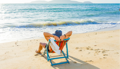 Happy retiree enjoying a relaxing beach vacation, thanks to a maximized Thrift Savings Plan (TSP).