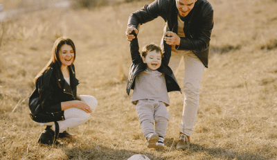 A family enjoys a moment of togetherness in an open field, symbolizing the protection and security offered by life insurance.