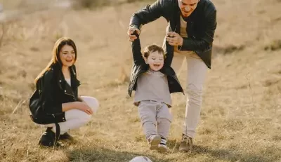 A family enjoys a moment of togetherness in an open field, symbolizing the protection and security offered by life insurance.