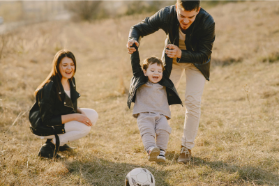 A family enjoys a moment of togetherness in an open field, symbolizing the protection and security offered by life insurance.