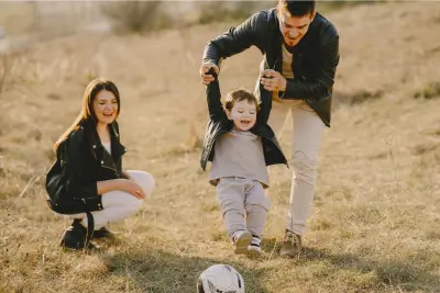 A family enjoys a moment of togetherness in an open field, symbolizing the protection and security offered by life insurance.