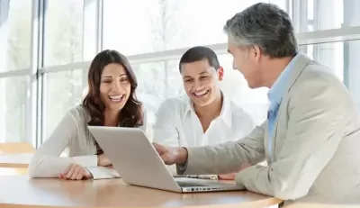 Three individuals with obscured faces are engaged in a discussion around a laptop, possibly regarding federal disability work processes.