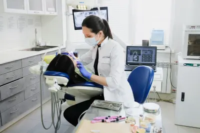 Dental professional performing a procedure on a patient, highlighting the benefits of FEDVIP through BENEFEDS.