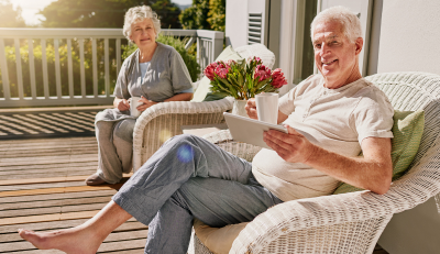 Retired couple relaxing on a porch, enjoying federal retirement benefits.
