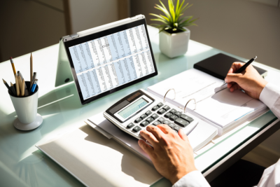 Professional calculating a FERS pension on a desk with tools.