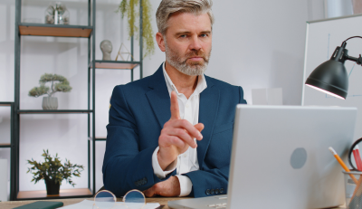 Professional man pointing while discussing Avoid FEGLI mistakes on a laptop.