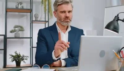 Professional man pointing while discussing Avoid FEGLI mistakes on a laptop.