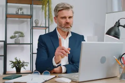Professional man pointing while discussing Avoid FEGLI mistakes on a laptop.