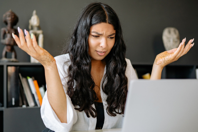 Confused woman looking at her laptop, frustrated by federal pension myths.