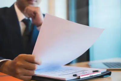 Professional reviewing documents for a federal employee benefit review.