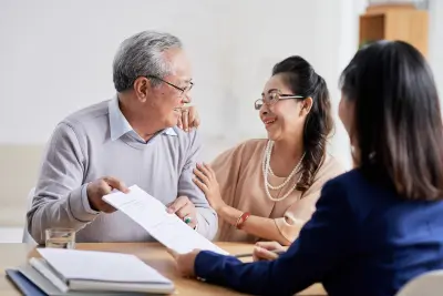 Smiling couple discussing FERS retirement plan with a professional advisor at a desk.