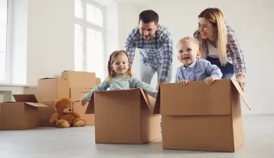 Happy family playing with their kids in a new home, highlighting security with life insurance term life.