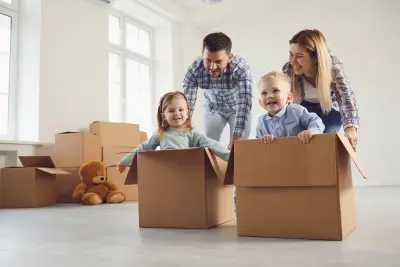 Happy family playing with their kids in a new home, highlighting security with life insurance term life.