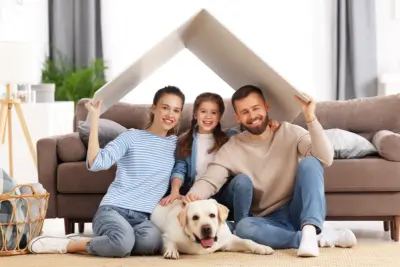 Family sitting together with a dog under a roof-like cover, symbolizing protection with supplemental life insurance.