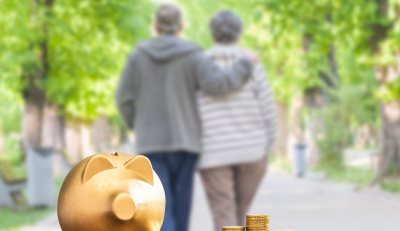Golden piggy bank with coins, symbolizing retirement savings, and Thrift Savings Program, a couple walking in the background.