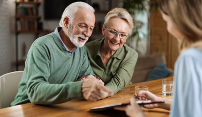 Senior couple discussing federal retirement plans with The Benefit Coordinators at a wooden table.