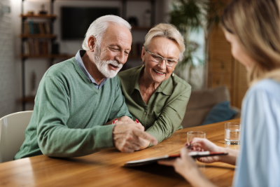 Senior couple discussing federal retirement plans with The Benefit Coordinators at a wooden table.