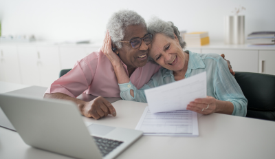 Happy senior couple reviewing documents about the age for drawing Social Security.
