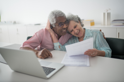 Happy senior couple reviewing documents about the age for drawing Social Security.