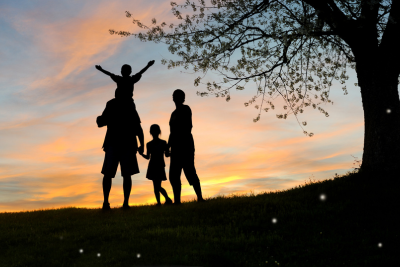 Silhouette of a happy family under a tree at sunset, symbolizing security and SSA death benefits support.
