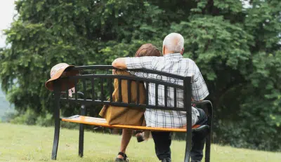 Older couple sitting on a bench thinking about when to apply for social security benefits