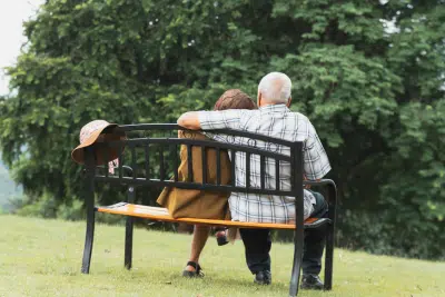 Older couple sitting on a bench thinking about when to apply for social security benefits