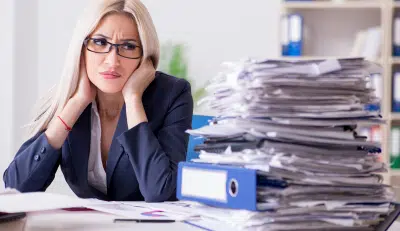 Stressed woman reviewing documents on whether an inherited IRA is taxable.