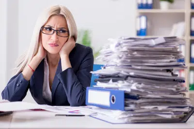 Stressed woman reviewing documents on whether an inherited IRA is taxable.