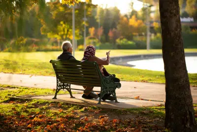 Retired couple sitting on park bench discussing TSP withdrawal options